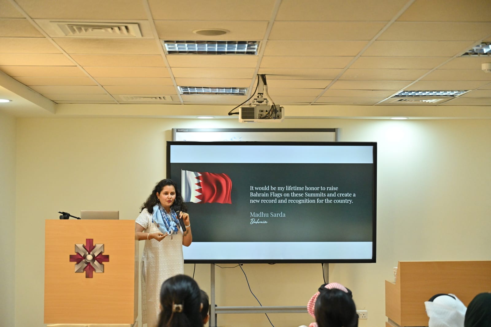 Madhu Sarda delivering her keynote at ACME, speaking about raising the Bahrain flag on the world's highest summits